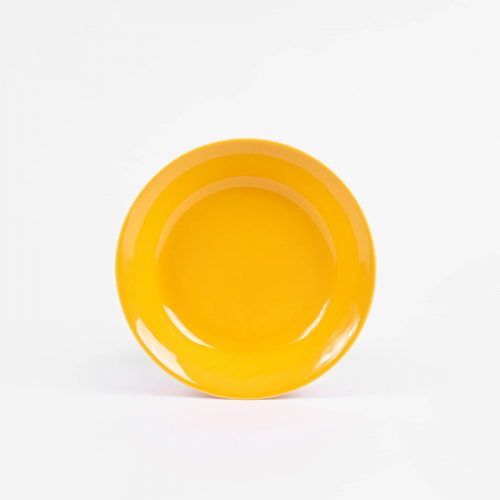 L'assiette creuse ronde en porcelaine en jaune solaire fabriqué en france